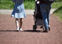 a man and woman walking with stroller